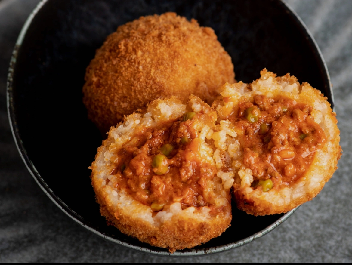 Bolognese arancini in black bowl