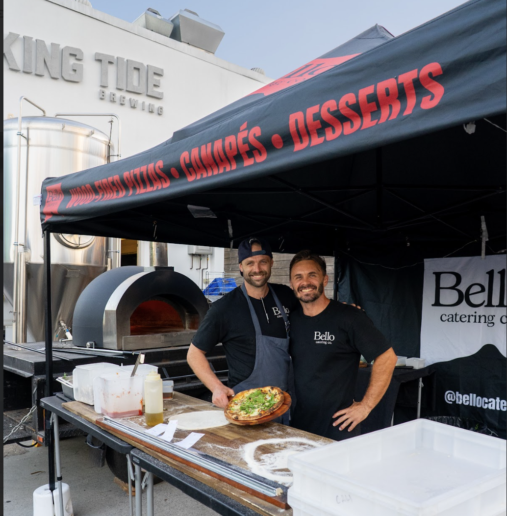 Bello Catering Co. founders Callum and team at the woodfired pizza marquee with fresh pizza